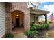 Brick entryway with arched alcove and a wooden door at 304 Woodstock Seven Dr, Woodstock, GA 30188
