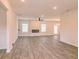 Open living room with wood-look floors, fireplace, and ceiling fan at 1621 Fuma Leaf Way, Mcdonough, GA 30253