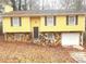 Ranch-style home with yellow siding, stone accents, and attached garage at 1593 Cherry Hill Ln, Conyers, GA 30094