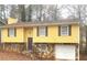 Ranch-style home with yellow siding, stone accents, and attached garage at 1593 Cherry Hill Ln, Conyers, GA 30094
