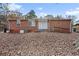 Brick ranch home with a spacious backyard covered in autumn leaves at 2707 Crescendo Nw Dr, Atlanta, GA 30318