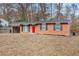 Brick ranch house with red door, attached carport, and landscaped yard at 2707 Crescendo Nw Dr, Atlanta, GA 30318