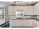 White kitchen with granite counters, ample cabinetry, and a window above the sink at 243 Yorkshire Ln, Villa Rica, GA 30180