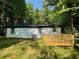 Back exterior showcasing a white brick house with a wooden deck and green lawn at 3426 Treadwell Sw Cir, Atlanta, GA 30331