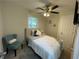 Cozy bedroom with a ceiling fan, teal accent chair, and wall-mounted TV at 3426 Treadwell Sw Cir, Atlanta, GA 30331