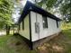 Side exterior view of a white brick house with black trim and surrounding trees at 3426 Treadwell Sw Cir, Atlanta, GA 30331