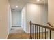 Upstairs hallway with carpeted floors and a wooden railing at 1620 Fuma Leaf Way, Mcdonough, GA 30253