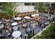 Outdoor restaurant patio with tables and umbrellas, surrounded by greenery at 90 Sheridan Dr, Atlanta, GA 30305