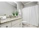 Well-lit bathroom with granite countertop, white cabinets, and shower at 745 Woodscape Trl, Alpharetta, GA 30022