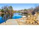 Picturesque lake view with a stone path, railing, and landscaping at 745 Woodscape Trl, Alpharetta, GA 30022