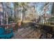 Spacious back deck with seating, a table, and a view of the wooded backyard at 242 Viola Dr, Dallas, GA 30157