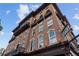 Brick building with decorative iron balconies and a sign for 