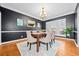 Dining room features dark accent walls, hardwood floors, chair rail molding, and chandelier at 8195 Majors Glen Ct, Cumming, GA 30041