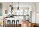 Modern kitchen boasts white cabinets, stainless steel appliances, and an island with seating at 9129 Selborne Ln, Chattahoochee Hills, GA 30268