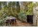 Private patio with wooden table and metal chairs and gate at 9129 Selborne Ln, Chattahoochee Hills, GA 30268