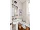 Elegant powder room with pedestal sink and hardwood floors at 9129 Selborne Ln, Chattahoochee Hills, GA 30268