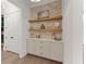 Butlers pantry with floating shelves, brick backsplash, and cabinets at 336 Mont Harmony Sw Rd, Powder Springs, GA 30127