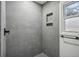 Grey tiled shower with built-in shelves and window at 4051 Glenda Dr, College Park, GA 30337