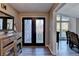 Foyer with decorative double doors, wood flooring, and a wood console table at 1470 Stone Lea Dr, Oxford, GA 30054