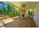 Covered back porch with a brick fireplace, wood decking, and wooded views at 119 Terrace View Dr, Acworth, GA 30101