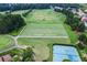 Aerial view of a driving range next to a golf course and tennis courts at 5392 Heron Bay Blvd, Locust Grove, GA 30248