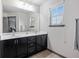 Modern bathroom with double vanity, dark cabinets, and a large mirror at 4958 Mcever View Dr, Sugar Hill, GA 30518