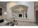 View of the kitchen's granite countertops, double sink, and open pass-through to the living area at 4958 Mcever View Dr, Sugar Hill, GA 30518