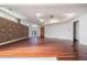 Large room with exposed brick, hardwood floors, and a door leading outside at 1112 Delaware Se Ave, Atlanta, GA 30316