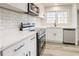 White kitchen features stainless steel appliances, white subway tile backsplash, quartz counters at 1004 Forrest Se Dr, Atlanta, GA 30354