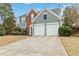 Two-story house with brick and gray siding, two-car garage, and landscaping at 3915 Lake Burton Dr, Duluth, GA 30097