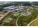 An aerial view of a community park with putting greens, a pond, and buildings at 687 Summitt Hill Way, Cumming, GA 30040