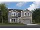 Two-story home with gray siding, stone accents, and a two-car garage at 106 Henley St, Canton, GA 30114