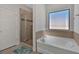 Bathroom with a soaking tub, shower, and neutral tile at 268 Bonnie Sue Dr, Villa Rica, GA 30180