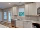 Bright kitchen featuring white cabinets, stainless steel appliances, and light granite countertops at 4230 Moore Rd, Conley, GA 30288