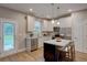 Modern kitchen with white cabinets, island, and stainless steel appliances at 4230 Moore Rd, Conley, GA 30288