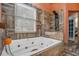Bathroom with a jetted tub, tiled walls, and window with blinds at 2291 Wilkins Ct, Decatur, GA 30035