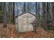 Storage shed in the backyard surrounded by trees and a wood fence at 2291 Wilkins Ct, Decatur, GA 30035