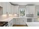 Modern white kitchen with sleek finishes, ample counter space, and lots of natural light at 5272 Poplar Springs Rd, Stone Mountain, GA 30083