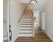 Wooden staircase with white risers and wooden handrail in a bright foyer at 5272 Poplar Springs Rd, Stone Mountain, GA 30083