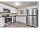 Updated kitchen boasts white cabinets, stainless steel appliances, and granite countertops at 1767 Big Horn Se Ct, Conyers, GA 30013