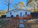 Charming exterior with a blue door, wooden deck, fenced backyard, and mature trees at 2981 Grand Sw Ave, Atlanta, GA 30315