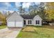 Gray house with two-car garage and landscaped yard at 1299 Paddocks Way, Powder Springs, GA 30127