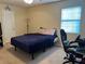 Bedroom with carpeted floors, a bed, a desk, an office chair, and a window at 2711 Greystone Ct, Austell, GA 30106