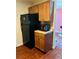Another view of the kitchen highlighting the black refrigerator, microwave, and wood cabinets at 2711 Greystone Ct, Austell, GA 30106