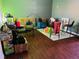 A different angle of the living room with wood floors, furniture, boxes, and a green accent wall at 2711 Greystone Ct, Austell, GA 30106