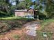 Dilapidated home in wooded lot with boarded-up windows and overgrown yard at 244 Morris Brown Nw Ave, Atlanta, GA 30314