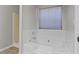 Bathroom with white tile, soaking tub, and window with blinds at 2921 Ward Lake Way, Ellenwood, GA 30294