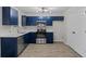 Modern kitchen with blue cabinetry, stainless steel appliances, and white countertops at 2921 Ward Lake Way, Ellenwood, GA 30294