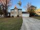 Two-story house with a tan exterior, attached garage, and landscaping at 5830 Burdett Ridge, Atlanta, GA 30349