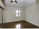 Spacious bedroom with a ceiling fan, mirrored closet doors, and large window at 1985 Mount Vernon Pl, Atlanta, GA 30338